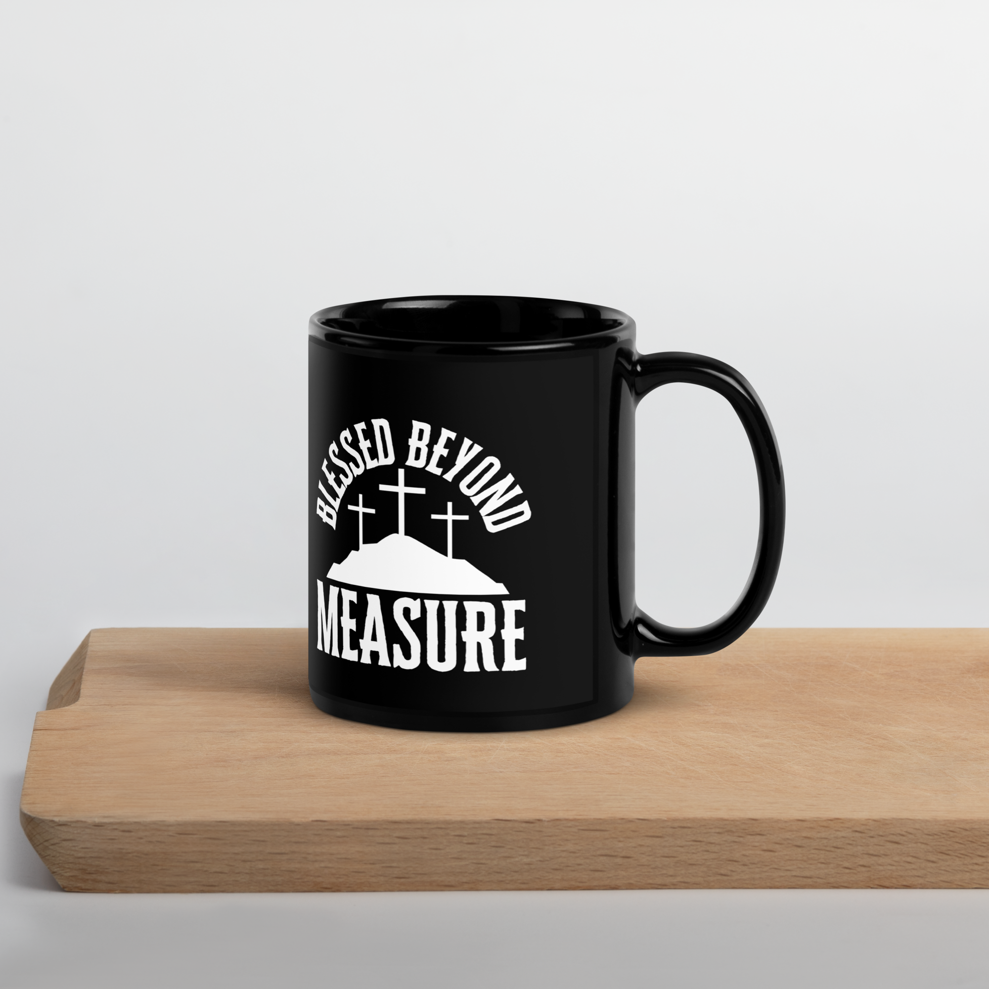 Front view of "Blessed Beyond Measure" coffee mug: Black ceramic coffee mug with bold white lettering that reads "Blessed Beyond Measure," inspired by Psalm 23:5.