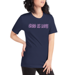 Female model wearing Heavenly Crafted's 'God Is Love' T-shirt in Navy, shown in a mockup. The vibrant neon text makes a bold statement of faith and style for everyday inspiration.