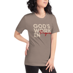 Female model wearing Heavenly Crafted's 'God's Work in Progress' T-shirt in Tan, offering a stylish and comfortable look that symbolizes personal growth and faith.