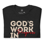 Folded Tan T-shirt by Heavenly Crafted with 'God's Work in Progress' text, offering a soft and comforting reminder of personal growth and faith, inspired by Philippians 1:6.