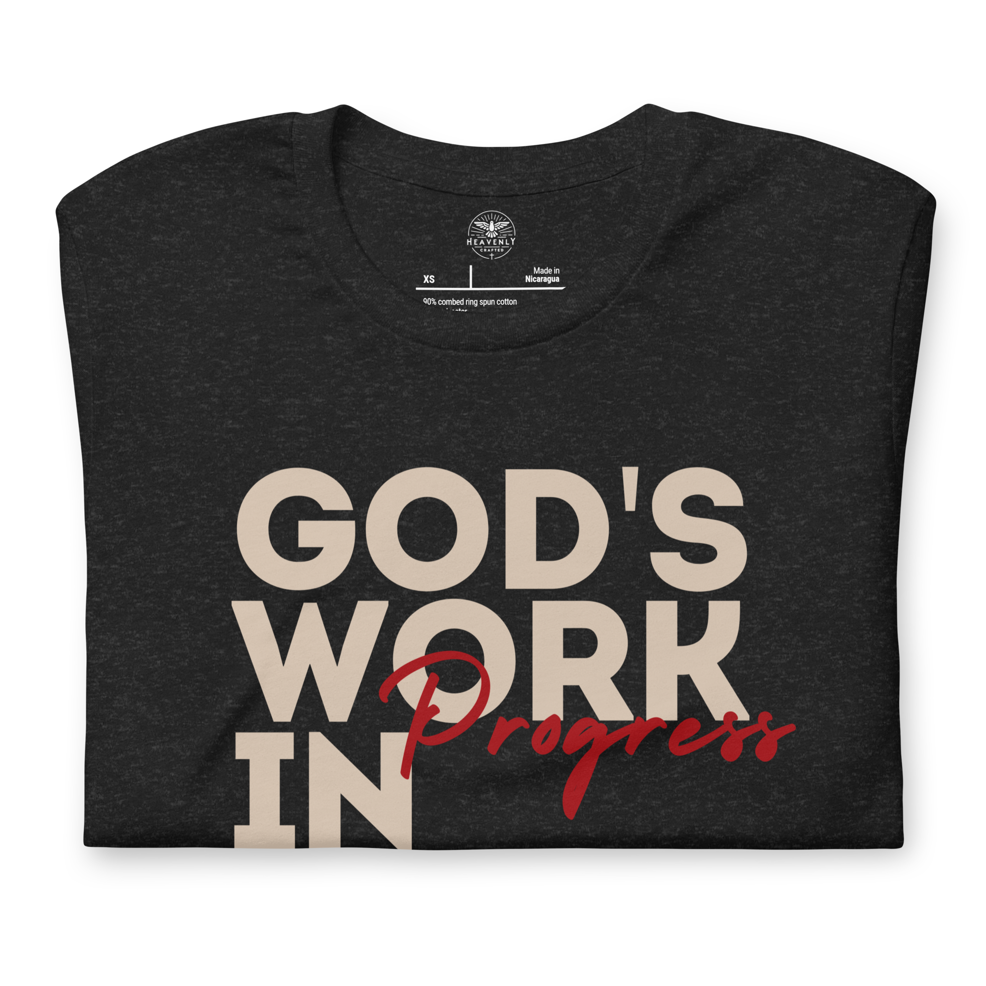 Folded Tan T-shirt by Heavenly Crafted with 'God's Work in Progress' text, offering a soft and comforting reminder of personal growth and faith, inspired by Philippians 1:6.