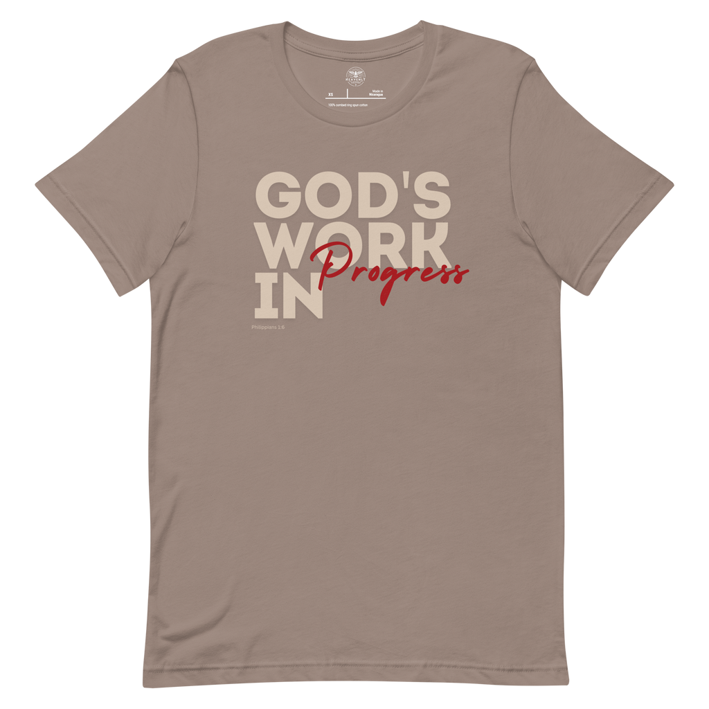 Front view of Heavenly Crafted's 'God's Work in Progress' T-shirt in Tan, showcasing the inspirational text design in bold lettering. A reminder of faith and growth inspired by Philippians 1:6. Shirt laid out natrually