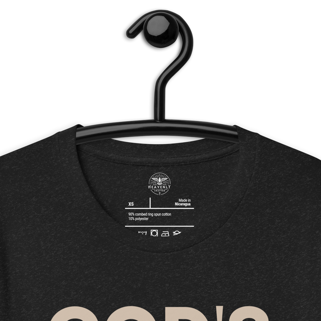 Heavenly Crafted's 'God's Work in Progress' T-shirt in Charcoal Black hanging on a wooden hanger, featuring a simple and bold text design. Perfect for expressing faith and embracing growth.