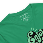 Folded green T-shirt with 'Enjoy Every Moment' in graffiti script, showcasing the vibrant design and soft, quality fabric perfect for daily wear and inspiration.