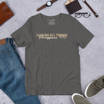 Display of 'I Can Do All Things' T-shirt in Asphalt on shop storefront."