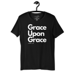 Front view of 'Grace Upon Grace' T-shirt hanging on a wooden hanger.
