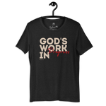 Charcoal Black 'God's Work in Progress' T-shirt hanging on a wooden hanger.