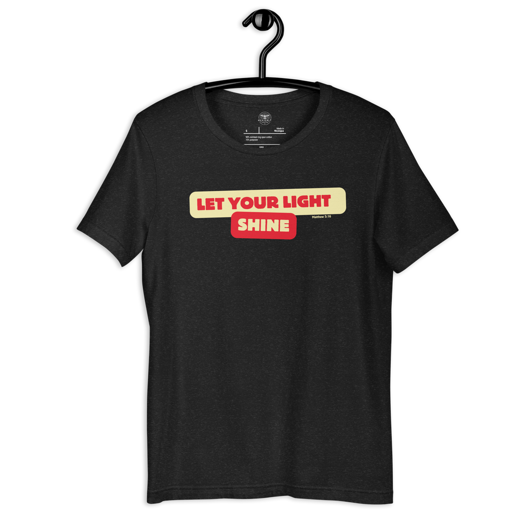 Black Heather 'Let Your Light Shine' T-shirt hanging on a wooden hanger, featuring bold yellow script lettering. Made from soft, breathable cotton, this shirt offers a stylish way to express faith and inspiration.