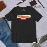 Front view of 'Let Your Light Shine' T-shirt in Black Heather fabric, featuring bold yellow script lettering. Made from soft, 100% combed and ring-spun cotton, this shirt offers a comfortable fit with an inspiring faith-based message.
