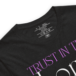Logo stamp inside 'Trust in the Lord' T-shirt in Black Heather, showing brand and care instructions.