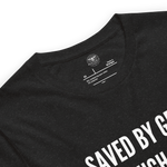 Logo stamp inside Black Heather 'Saved by Grace Through Faith' T-shirt, showing brand and care instructions.