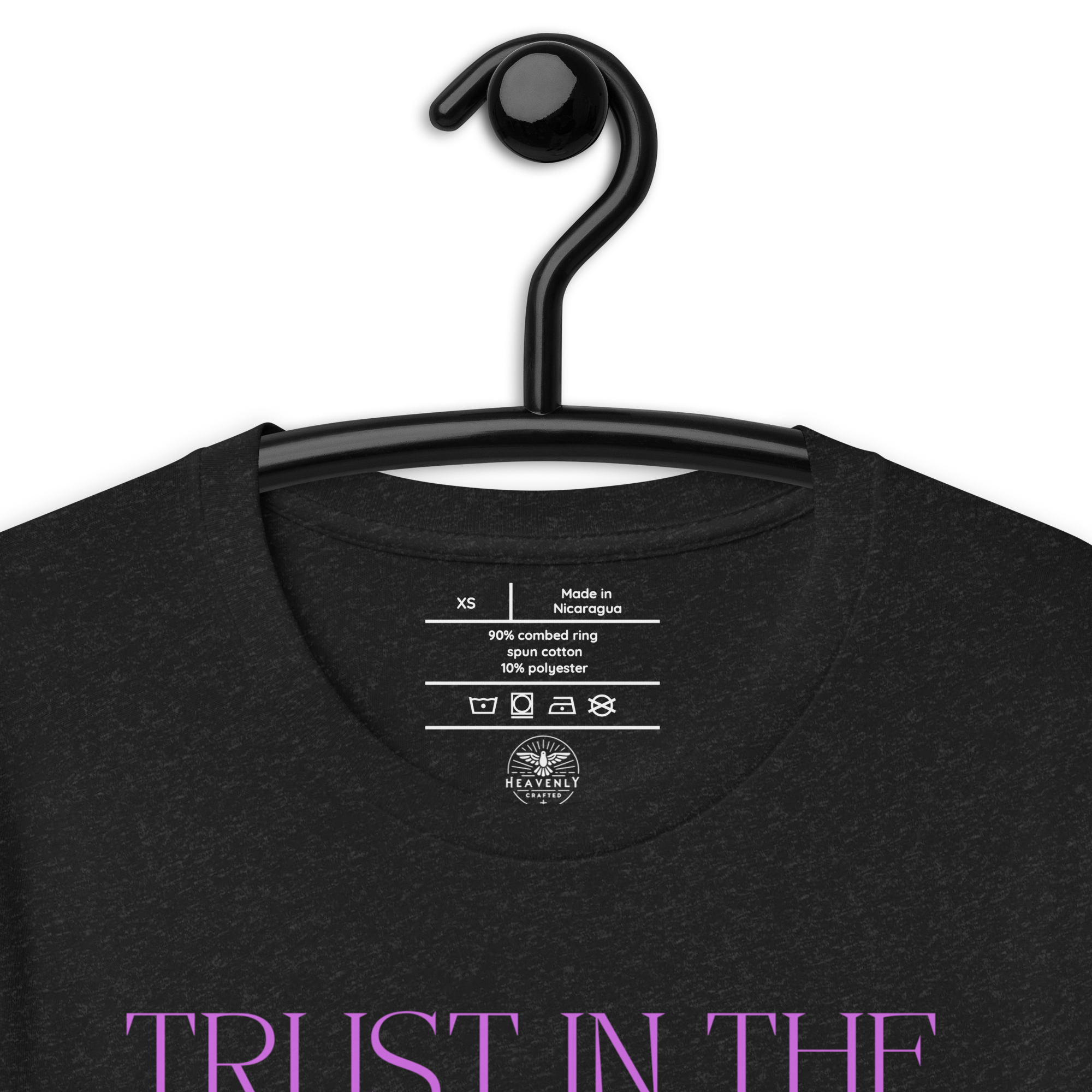 Logo stamp inside 'Trust in the Lord' T-shirt in Black Heather, showing brand and care instructions, on a hanger.