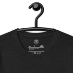 Logo stamp inside Black Heather 'Saved by Grace Through Faith' T-shirt, showing brand and care instructions., on a hanger. close angle