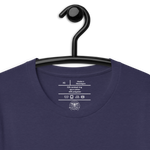 "Inside label of 'Hope Anchors the Soul' T-shirt, showing care instructions and fabric details, "Heather Midnight Navy 'Hope Anchors the Soul' T-shirt on wooden hanger.