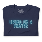 Folded navy T-shirt with 'Living on a Prayer' in vibrant neon lights script.