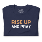 Folded navy T-shirt with 'Rise Up and Pray' in white script.