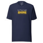Folded navy blue T-shirt with 'Let Your Light Shine' in white and yellow script.