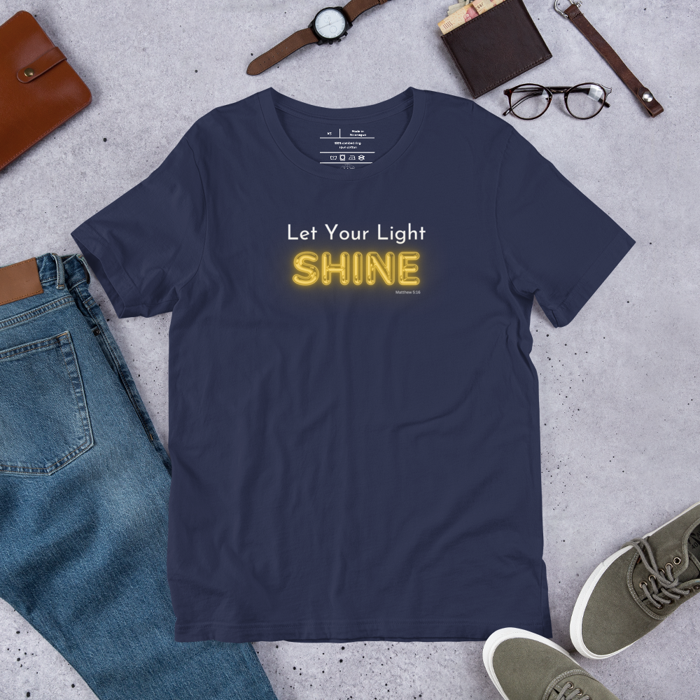 Main display mockup of 'Let Your Light Shine' T-shirt in navy blue in shop setting.