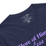 Inside label of 'More of Him, Less of Me' T-shirt showing brand and care details.