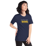 Model wearing 'Let Your Light Shine' T-shirt in navy, three-quarter view, glowing text.