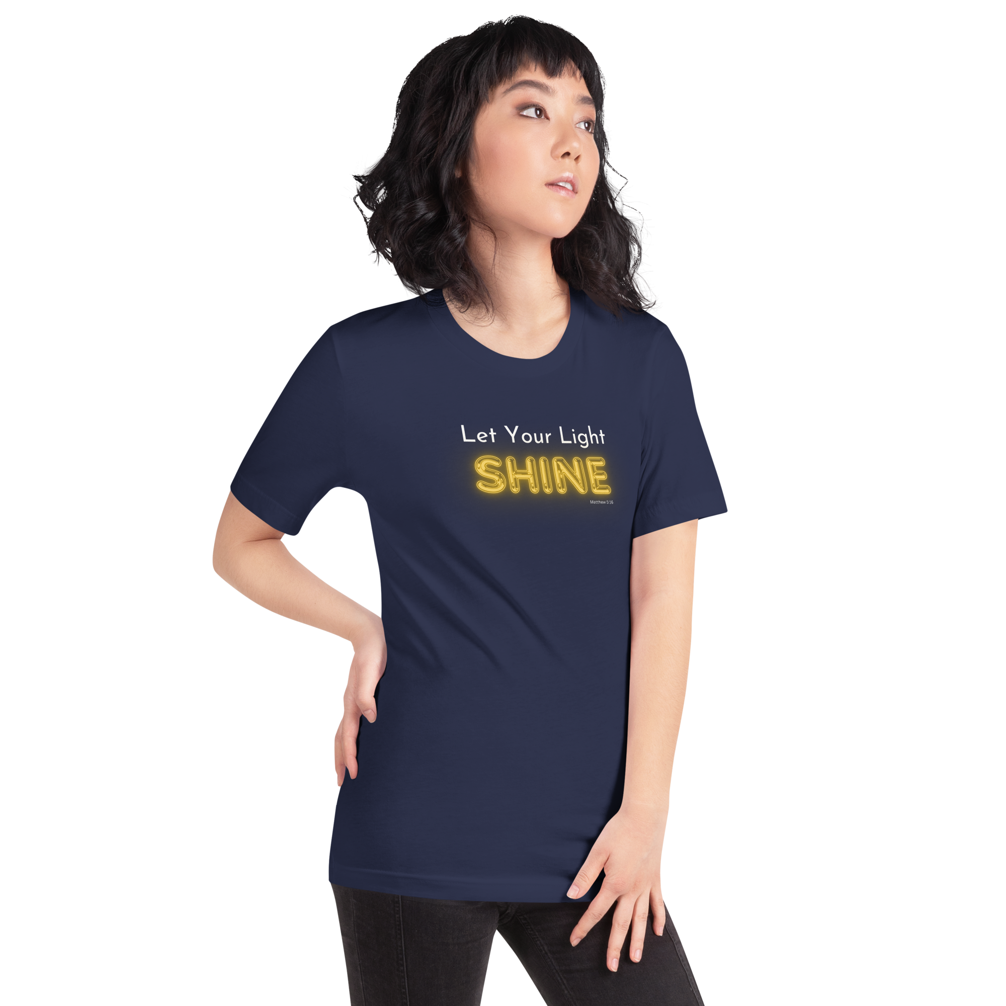 Model wearing 'Let Your Light Shine' T-shirt in navy, three-quarter view, glowing text.