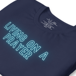 Close-up of neon 'Living on a Prayer' text on navy T-shirt, glowing effect.