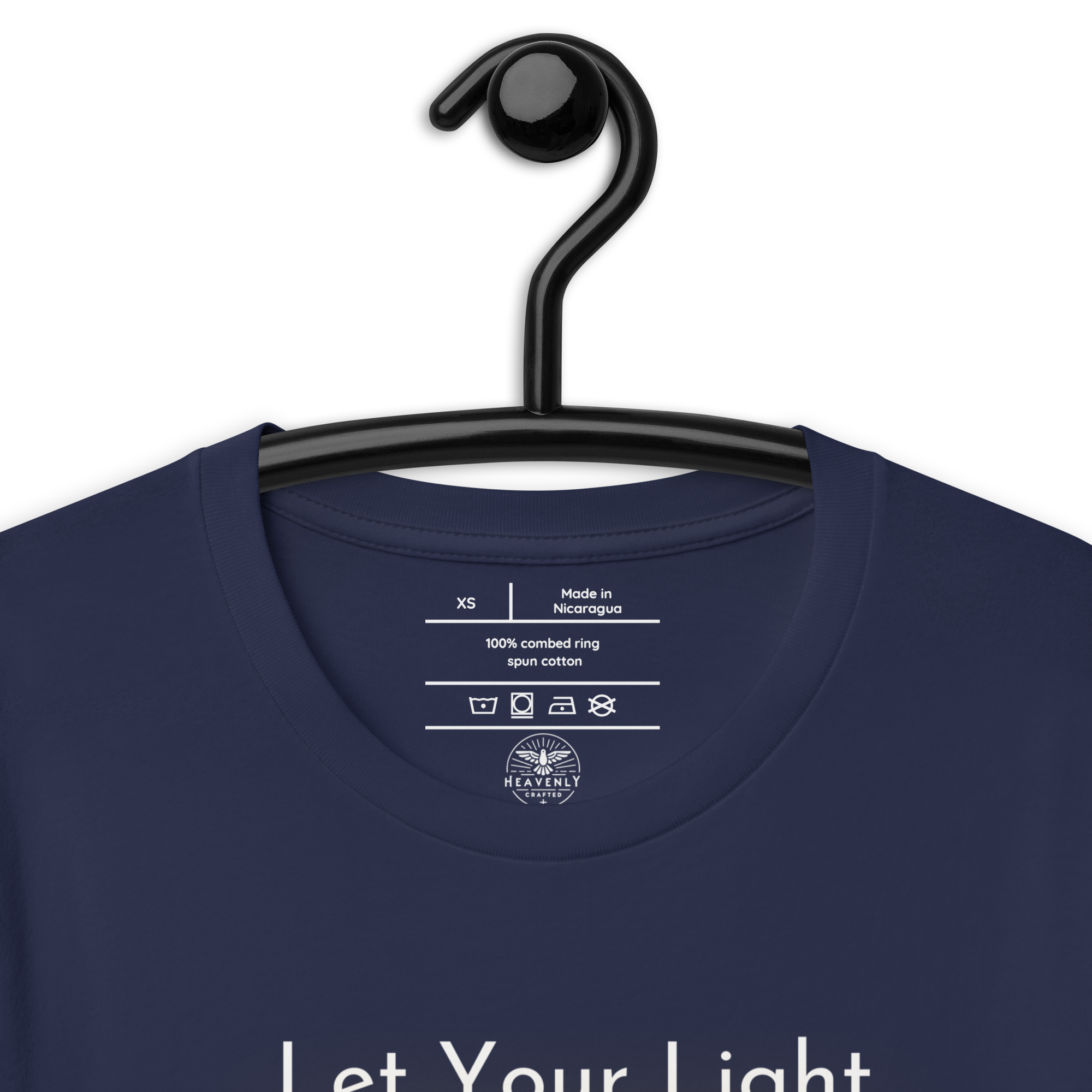 Logo stamp inside 'Let Your Light Shine' T-shirt in navy, showing brand and care instructions on a hanger