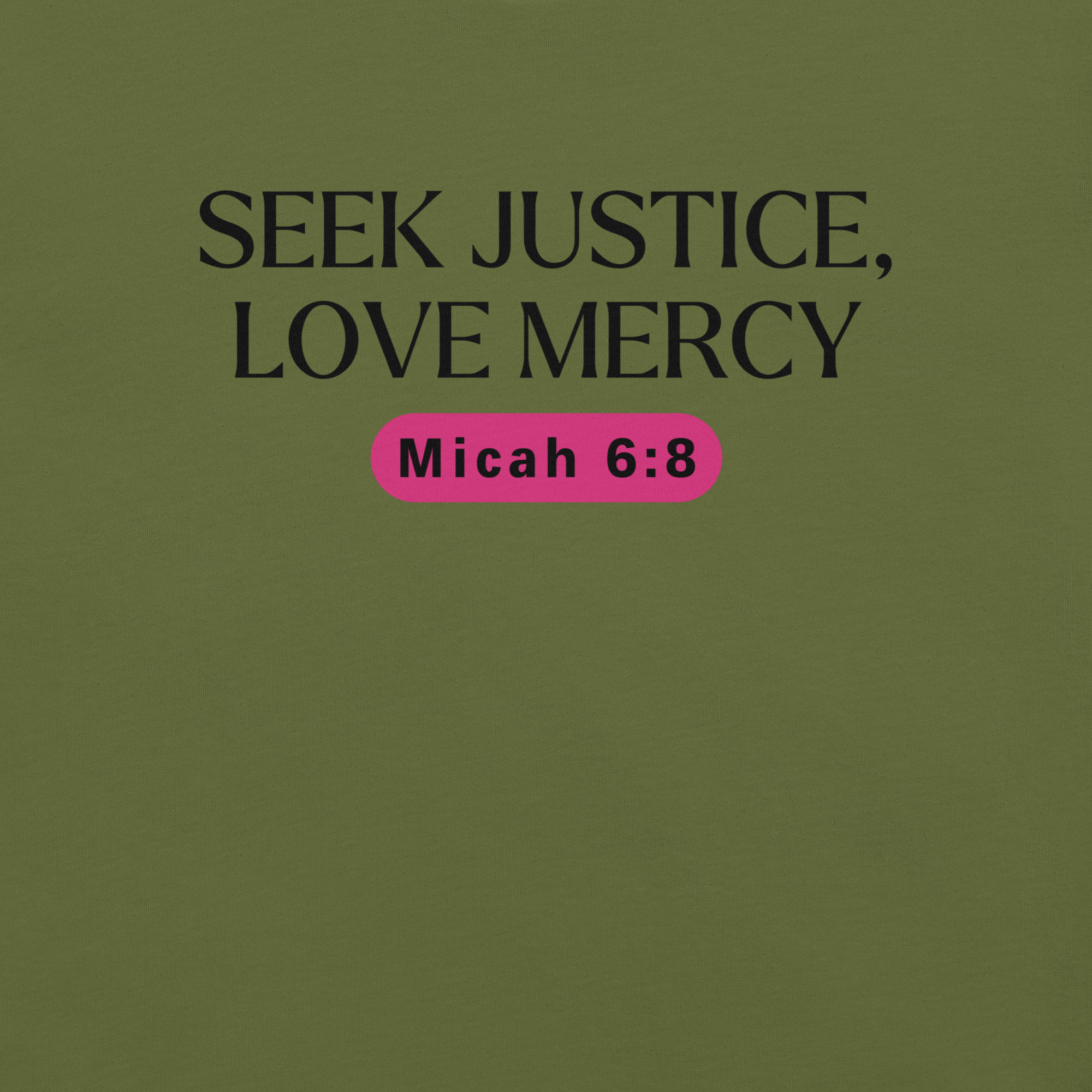 Close-up of the logo on the 'Army of Faith' T-shirt in Army Green, displaying the intricate black text and pink button-like design. Showcasing brand details and care instructions, this design draws inspiration from Ephesians 6:11, emphasizing the shirt's message of strength and protection.