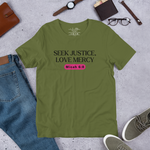Main display mockup of the 'Army of Faith' T-shirt in Army Green, showcased in a shop setting. Features bold black text and a pink button-like design, inspired by Ephesians 6:11. Perfect for expressing strength and faith in a stylish, comfortable way.