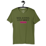 Army Green 'Army of Faith' T-shirt hanging on a wooden hanger, featuring bold black text and a pink button-like design. Made from 100% combed and ring-spun cotton, this shirt embodies a strong statement of faith and style.