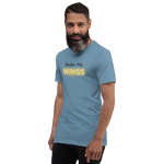 Model wearing 'Under His Wings' T-shirt in navy blue, three-quarter view.