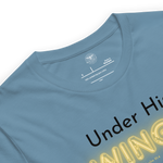 Logo stamp inside 'Under His Wings' T-shirt in navy blue, showing brand and care instructions.