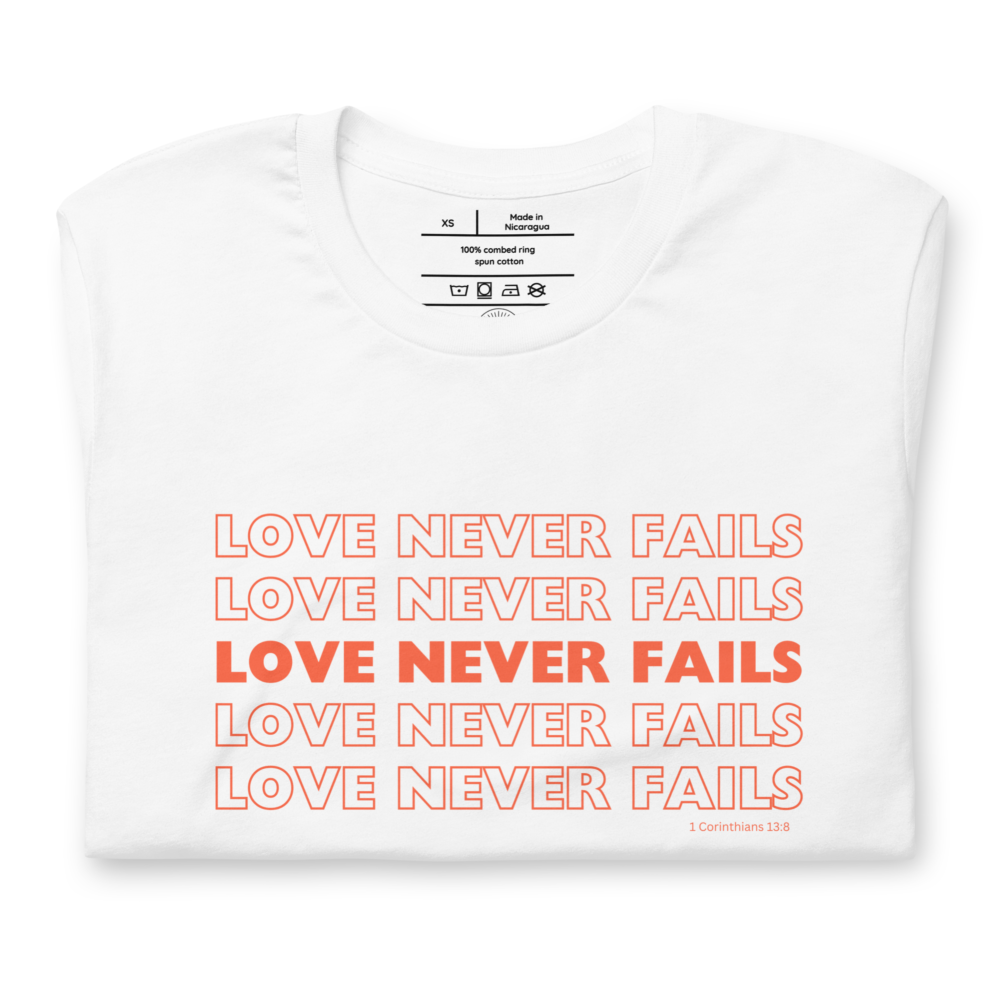 Folded White T-shirt with 'Love Never Fails' in red outline script.