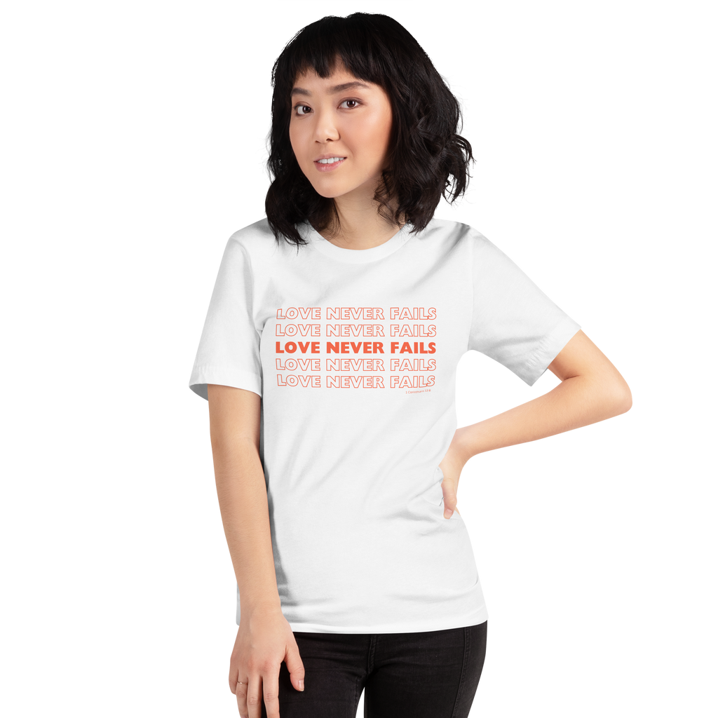 Model wearing 'Love Never Fails' T-shirt in White, side view.